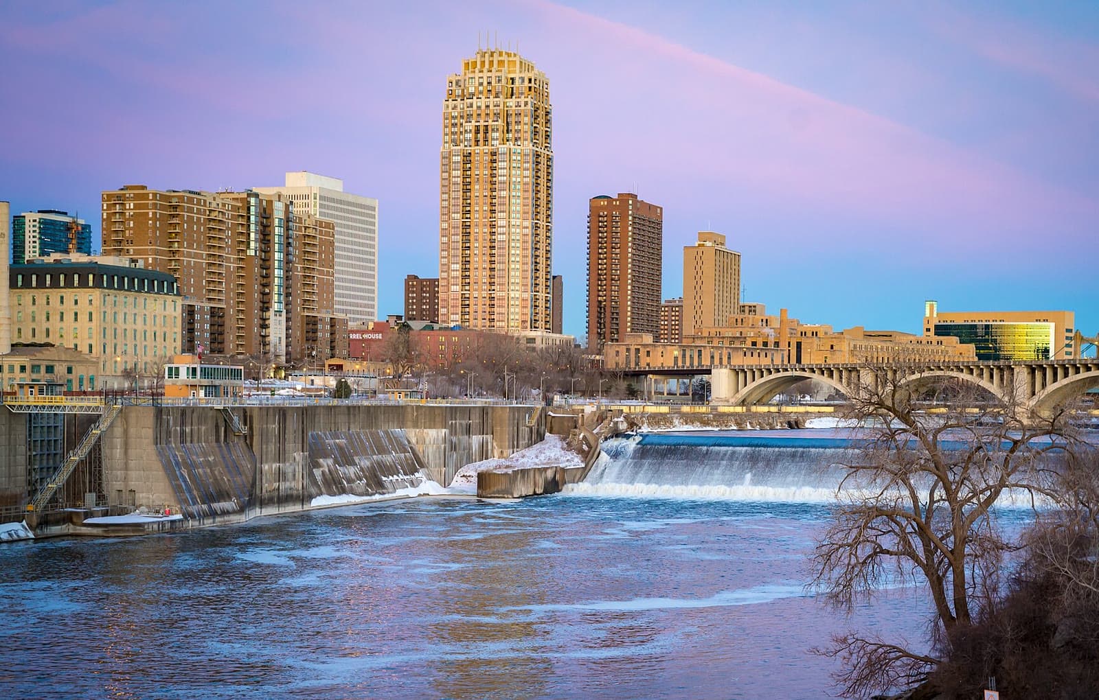 Downtown Minneapolis above St. Anthony Falls under a pink and blue sky: Rockstarr Media is casting new faces in Minneapolis
