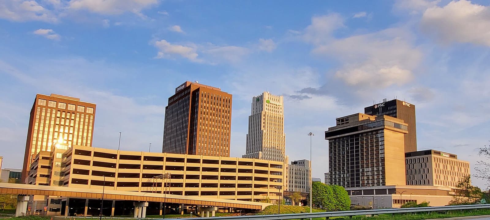 Downtown Akron's towers glowing in golden-hour light under a blue sky: Rockstarr Media is casting new faces in Akron