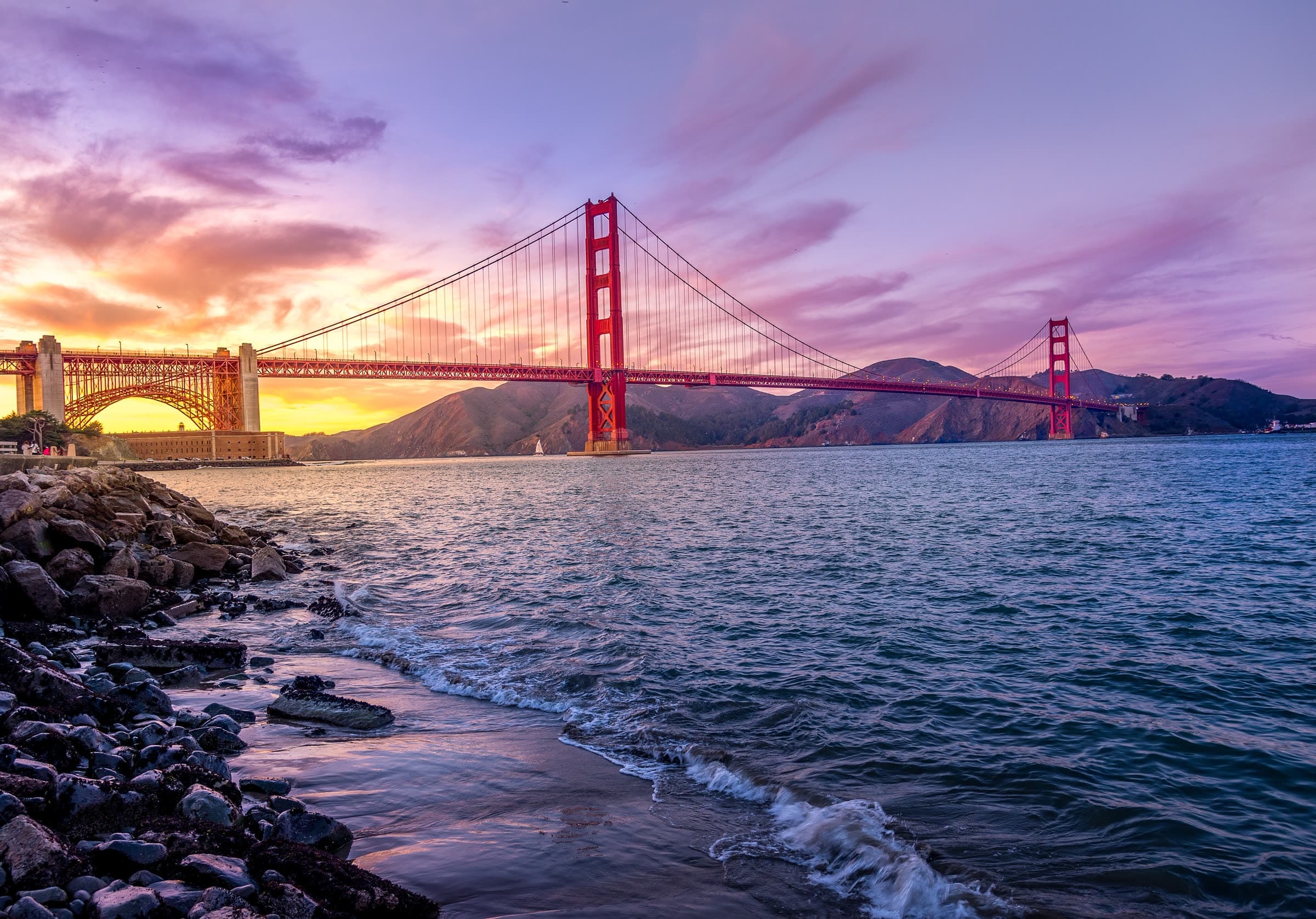 The Golden Gate Bridge at a purple sunset in San Francisco, California